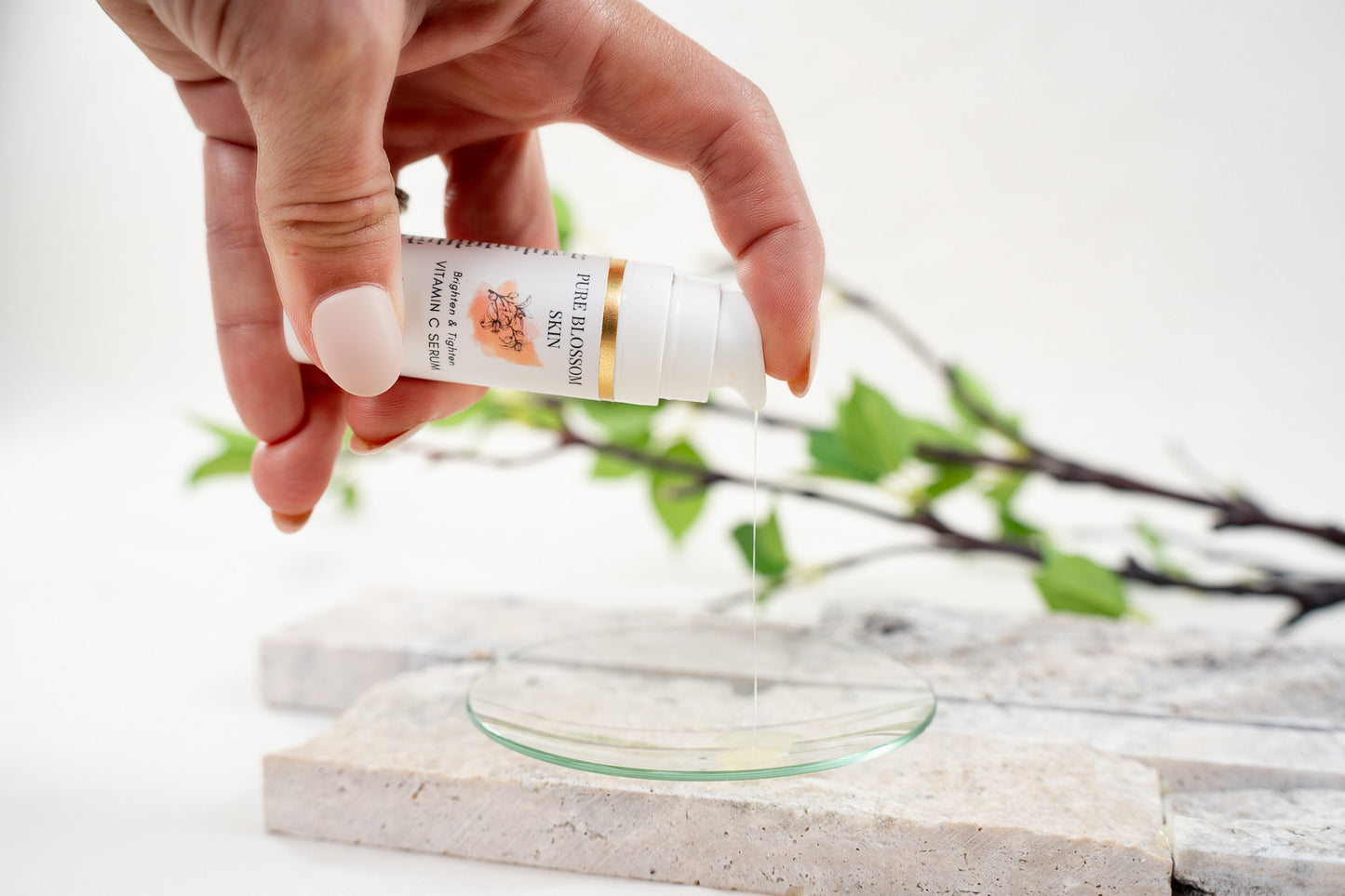 1/2oz opaque white pump bottle w/gold foil label pumping liquid serum onto glass dish Brighten & Tighten VITAMIN C SERUM | Pure Blossom Skin