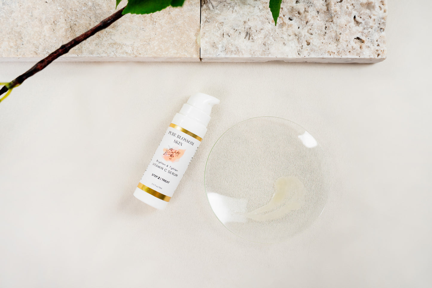 1/2 oz opaque white pump bottle of Brighten & Tighten VITAMIN C SERUM w/glass dish next to it w/clear, light Yellowish SERUM on it | Pure Blossom Skin