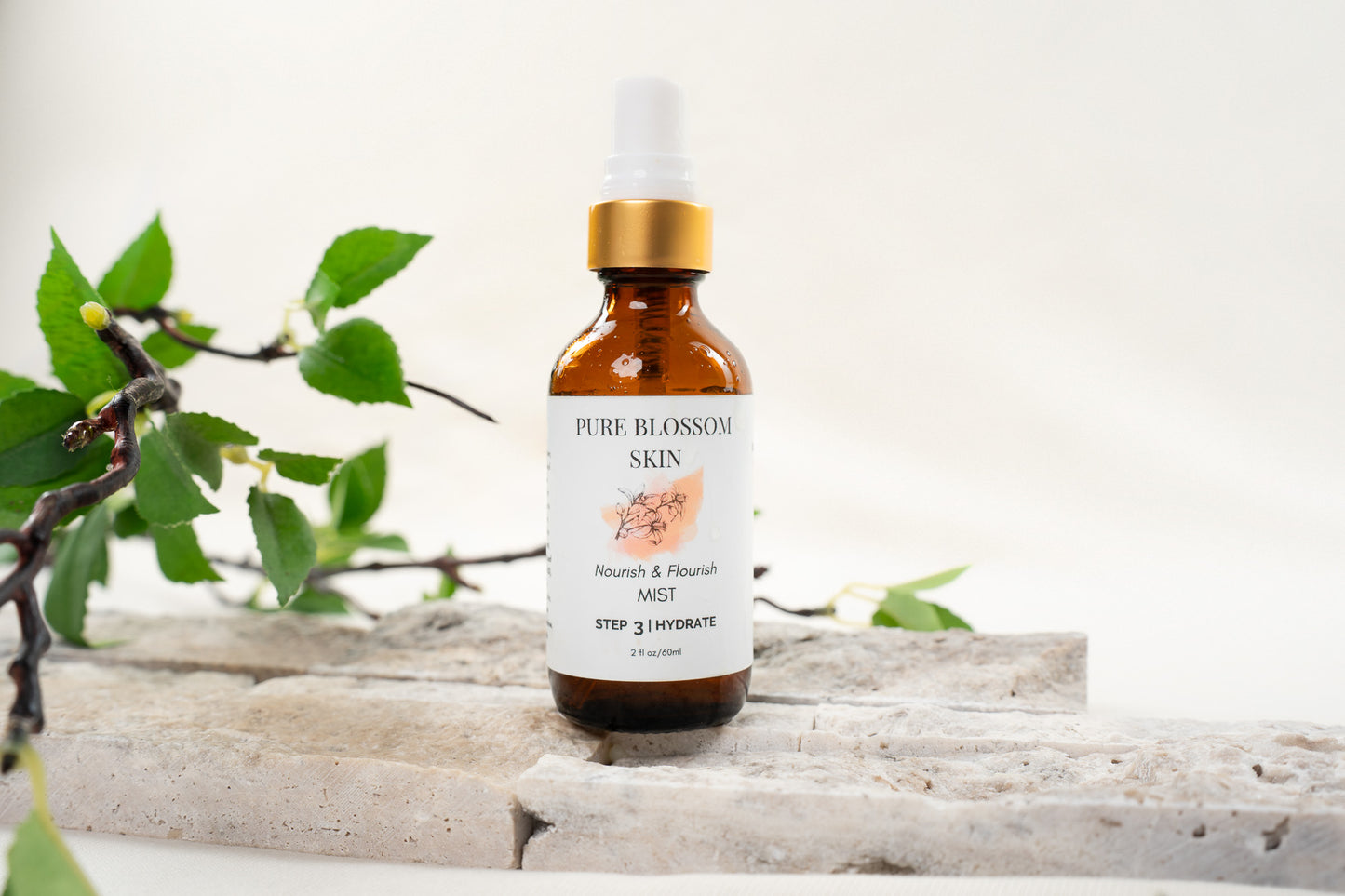 Close up of 2oz amber glass spray bottle w/matte gold trim of Nourish & Flourish MIST | Pure Blossom Skin