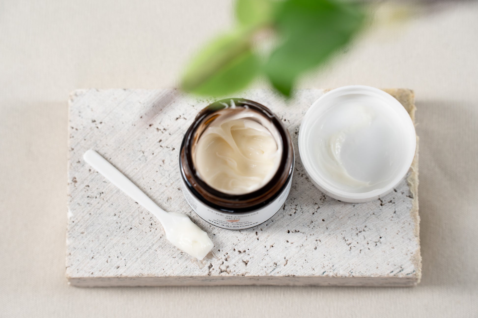 Looking down into open 1oz amber glass jar of Deep & Sleep NIGHT CREAM, with lid off next to jar. Jar filled with rich, decadent looking face cream | Pure Blossom Skin