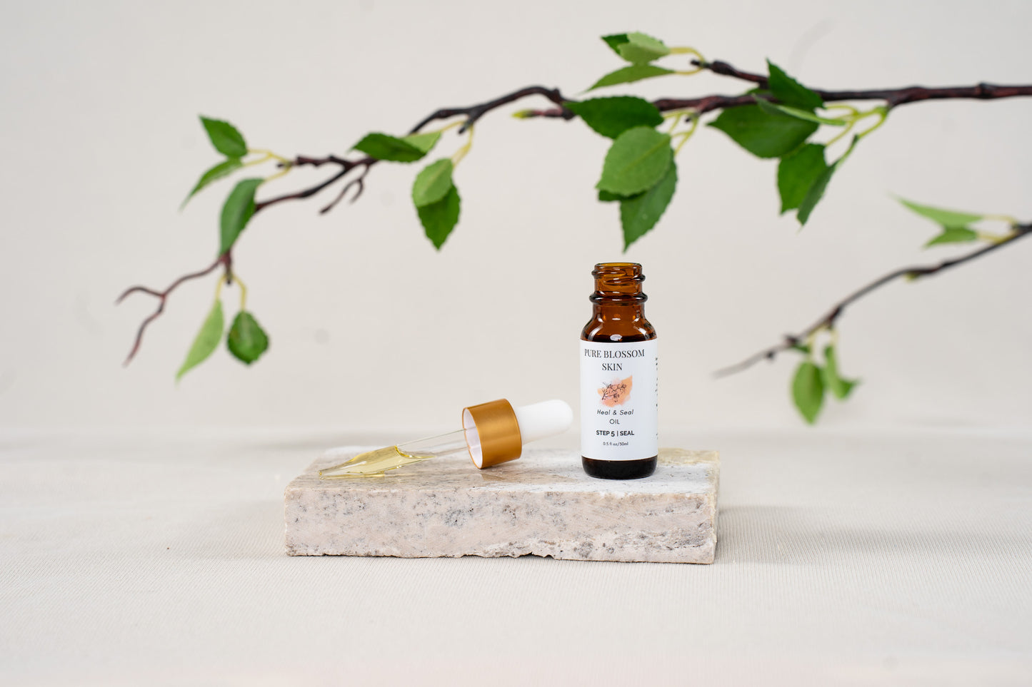 Gold trim dropper lid, with oil in the pipette, next to 1/2oz open amber glass bottle of Heal & Seal OIL | Pure Blossom Skin