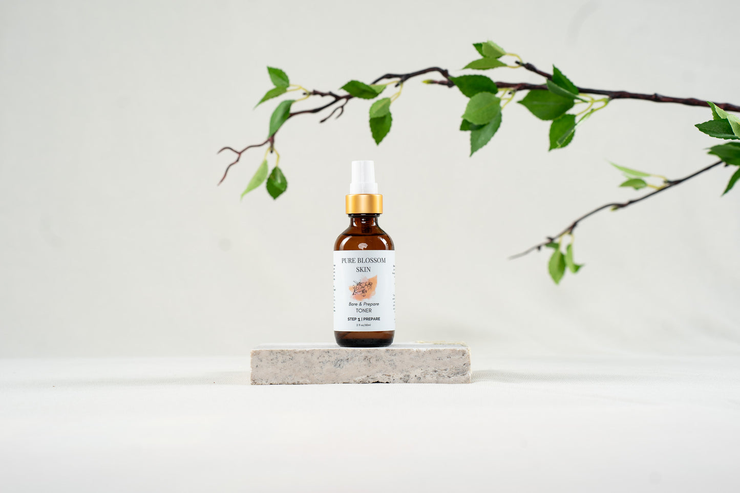 2 oz amber glass bottle with w/matte gold trim of Bare & Prepare TONER | Pure Blossom Skin