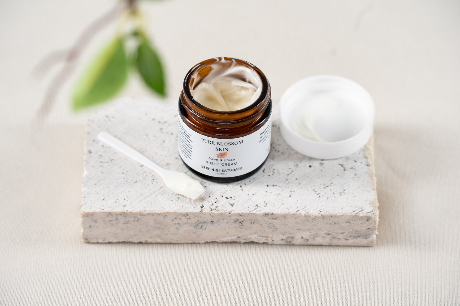 Looking at open 1oz amber glass jar of Deep & Sleep NIGHT CREAM, with lid off next to jar. Jar filled with rich, decadent looking face cream | Pure Blossom Skin
